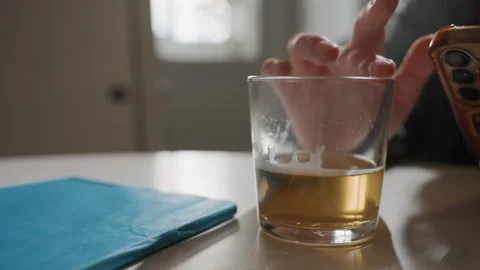 Relaxed person using phone. Individual multitasking with drinks and notes nearby Stock Footage 333475233