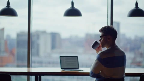 Relaxed programmer drinking tea looking distance in city view panoramic office Video stock 335247211