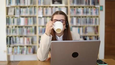 Relaxed sales manager drinks coffee while casually communicating with clients at Stockbeeldmateriaal 341656894