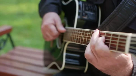 Relaxed setting featuring man expertly playing acoustic guitar outside Видео 331663481