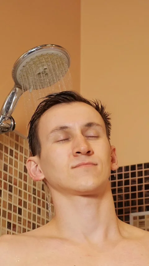 Relaxed shirtless man enjoying a refreshing hot shower in his bathroom, washing Stock Footage 344824033