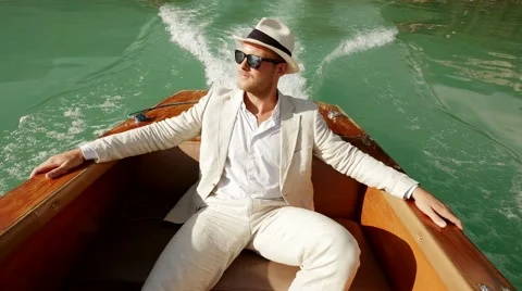Relaxed single man in casual suit enjoying life on boat deck riding over lake Stock-Footage 64800993