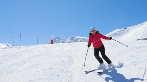 Relaxed skier confidently practicing carving techniques on sunny mountain day Video stock 323190358