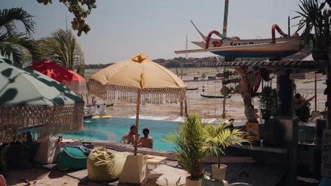 Relaxed tropical beachfront setting with colorful umbrellas Bali Vídeos de archivo 341513262