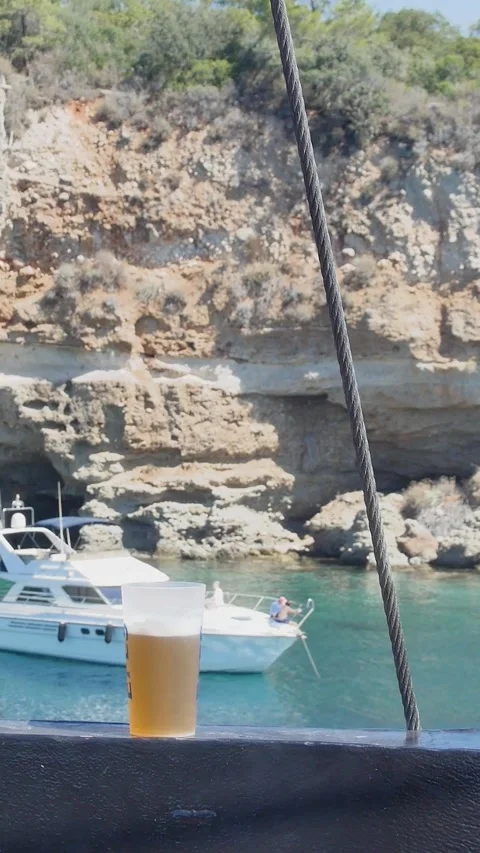 A relaxed vertical clip of a beer on a boat ledge, perfect for lifestyle tra Stock Footage 338314645