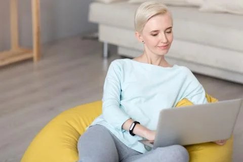 Relaxed woman using laptop while sitting Stock Photos