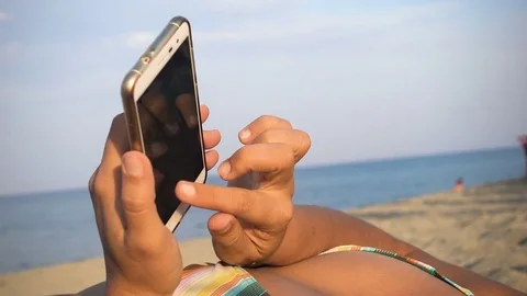 Relaxed woman's hands on the beach typing on smartphone 스톡 동영상 80179713