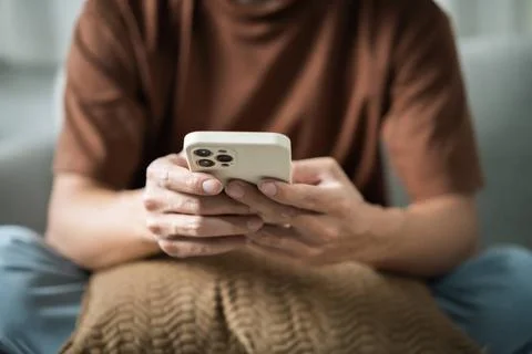 Relaxed young asian man using smart phone spending time checking news soci... 写真素材
