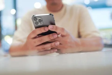 Relaxed young asian man using smart phone spending time checking news soci... 写真素材