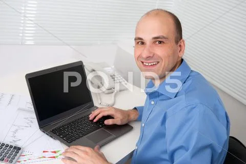 Relaxed young business man with laptop Stock Photos