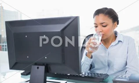 Relaxed young dark haired businesswoman drinking water Stock Photos