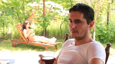 Relaxed Young Man Drinking Red Wine Woman Surprised Husband with Kiss in Garden Stock Footage 110091237