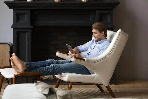 Relaxed young man using digital computer tablet. Stock Photos