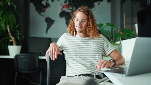 Relaxed young man working on laptop in headphones in office 스톡 동영상 244258332