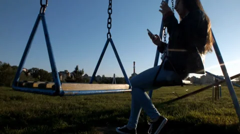 Relaxing after a long learning in the park on a swing, a cute girl enjoying the 動画素材 37847438