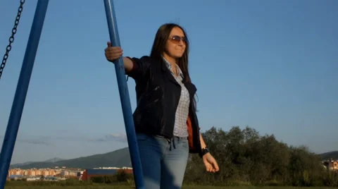 Relaxing after a long learning in the park by the swings, sweet girl who enjoys 스톡 동영상 37849321