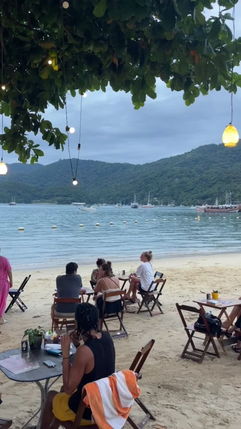 Relaxing at the beach with a few drinks in Vila do Abraão, Ilha Grande Stock Footage 293681609
