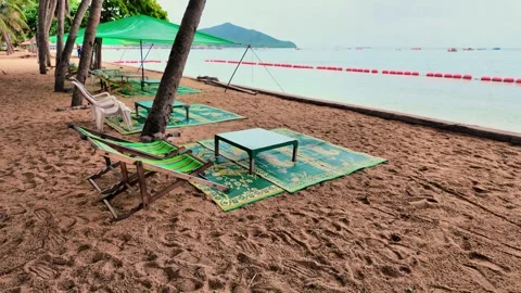 Relaxing Beach Setup With Chairs and Tables on Sandy Shoreline Near Water Stock Footage 280295653