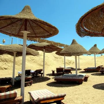 Relaxing on the Beach Under Wicker Umbrellas by Red Sea During a Sunny Day,.. Stock Photos