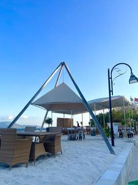 Relaxing Beachside Dining Area with Rustic Design and Blue Sky in View Foto stock