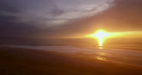 Relaxing cloudy sky during sunset with ocean waves splashing on beach Stock Footage 155602342