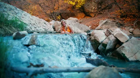 Relaxing in a colorful hot spring surrounded by autumn nature Stock Footage 310219859