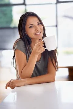 Relaxing with a cup of java. an attractive young woman drinking a coffee at home 스톡 사진
