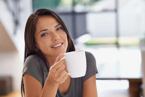 Relaxing with a cup of java. an attractive young woman drinking a coffee at home 스톡 사진