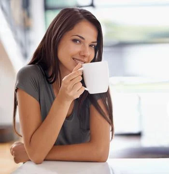 Relaxing with a cup of java. an attractive young woman drinking a coffee at home 스톡 사진