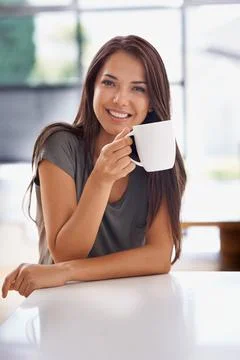 Relaxing with a cup of java. Shot of an attractive young woman drinking a cof Stock-Fotos