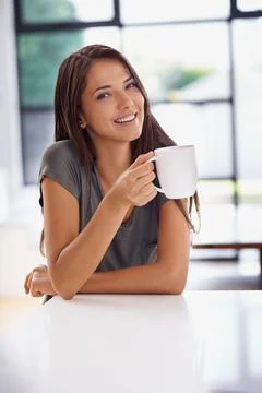 Relaxing with a cup of java. Shot of an attractive young woman drinking a coffee Foto stock