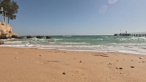 Relaxing Day at the Beach: Waves Gently Lapping Against the Golden Sand Under a 库存影片 330122792