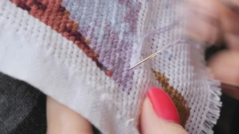 Relaxing hobby. Concentration. Cross-stitching close-up. The girl cross-stitches Video stock 195536129