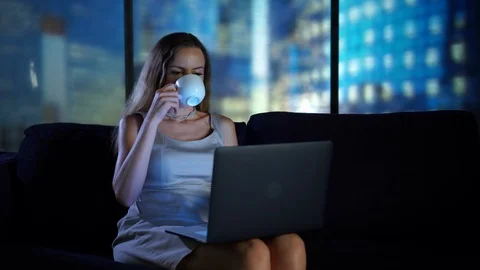 Relaxing at home, drinking tea coffe using laptop, searching social media, at Stock Footage 95151857
