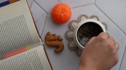 Relaxing morning setup with an open book, steaming cup of coffee. Stock Footage 296199747
