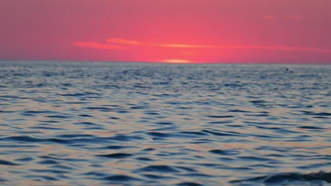 Relaxing ocean waves under colorful sunset sky, romantic atmosphere, 4K slow Stock Footage 332303533