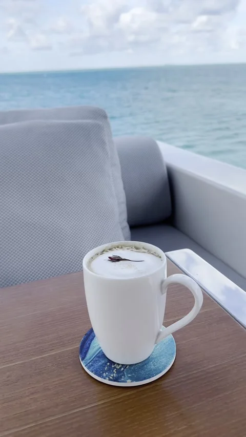 Relaxing oceanfront coffee experience: tranquil sea views and cozy comfort Stock Footage 319776918