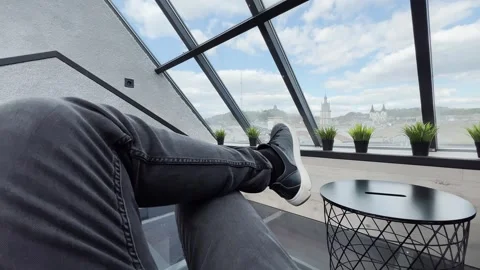 Relaxing by panoramic window with city view and modern interior. Stock Footage 312017623