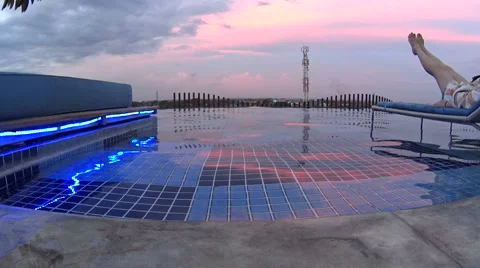 Relaxing by the pool at dusk after a long day of adventure Stock Footage 61042182