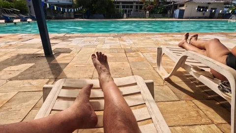 Relaxing by the pool under the sun at a local recreation area Видео 329063972