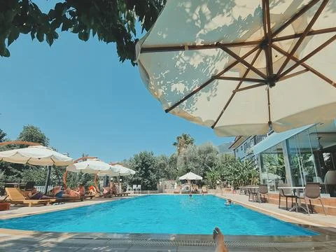 Relaxing by the pool. View of the pool, sun loungers and umbrellas. summer va Stock Photos