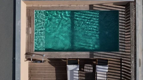 Relaxing by the poolside during a sunny afternoon at a tranquil retreat Stock Footage 319497734