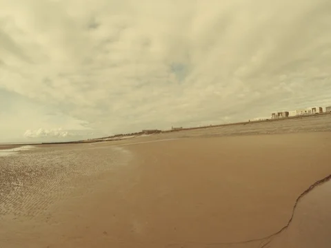 A relaxing retro rotating panning time lapse of a sandy beach on a cloudy day Stock Footage 77350285