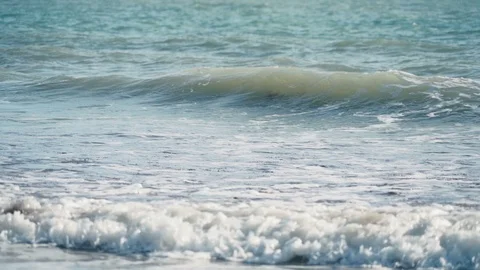 Relaxing slow motion view of small waves crashing onto beach Stock Footage 119534654