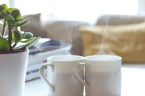 Relaxing sofa area with coffee table and hot drink in modern home interior Stock Photos