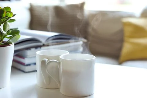 Relaxing sofa area with coffee table and hot drink in modern home interior Stock Photos