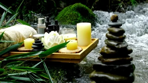 Relaxing spa setting with candles and flowers near water Video stock 332278958
