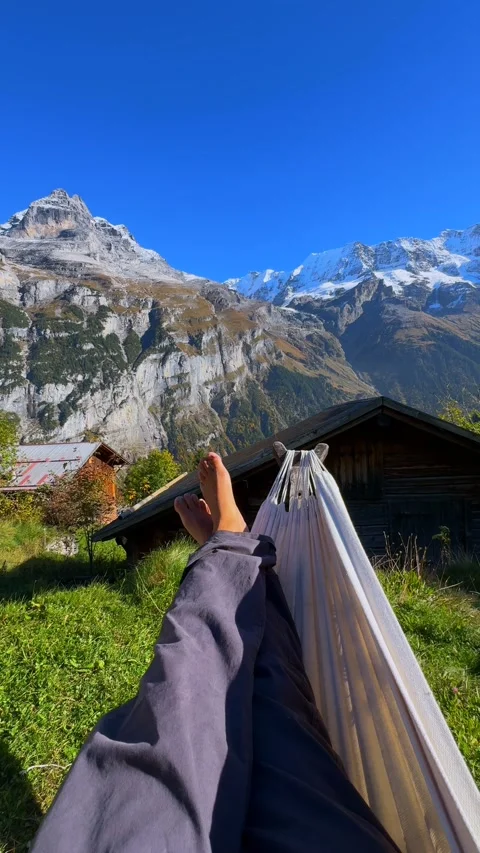 Relaxing swing bare feet Hammock Murren Mürren Gimmelwald Lauterbrunnen Valley Stock Footage 328610101
