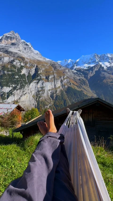 Relaxing swing bare feet Hammock Murren Mürren Gimmelwald Lauterbrunnen Valley Stock Footage 328610530