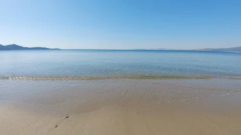 Relaxing view of clear water waves calmly wash backwards from sandy beach Stock Footage 130116744
